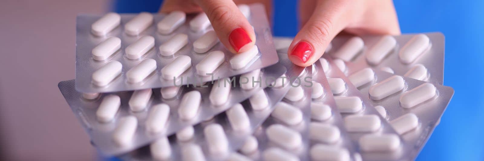 Person holds lot of pills in blister by kuprevich