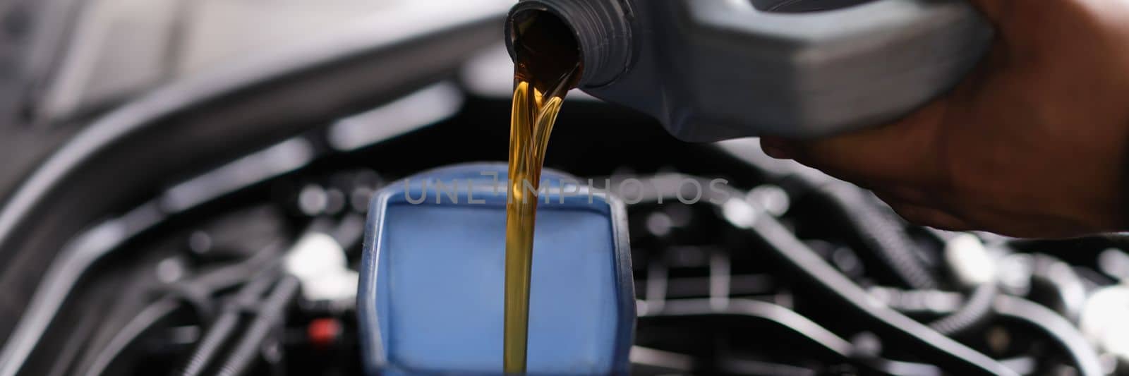 Pour gear oil into car through watering can by kuprevich