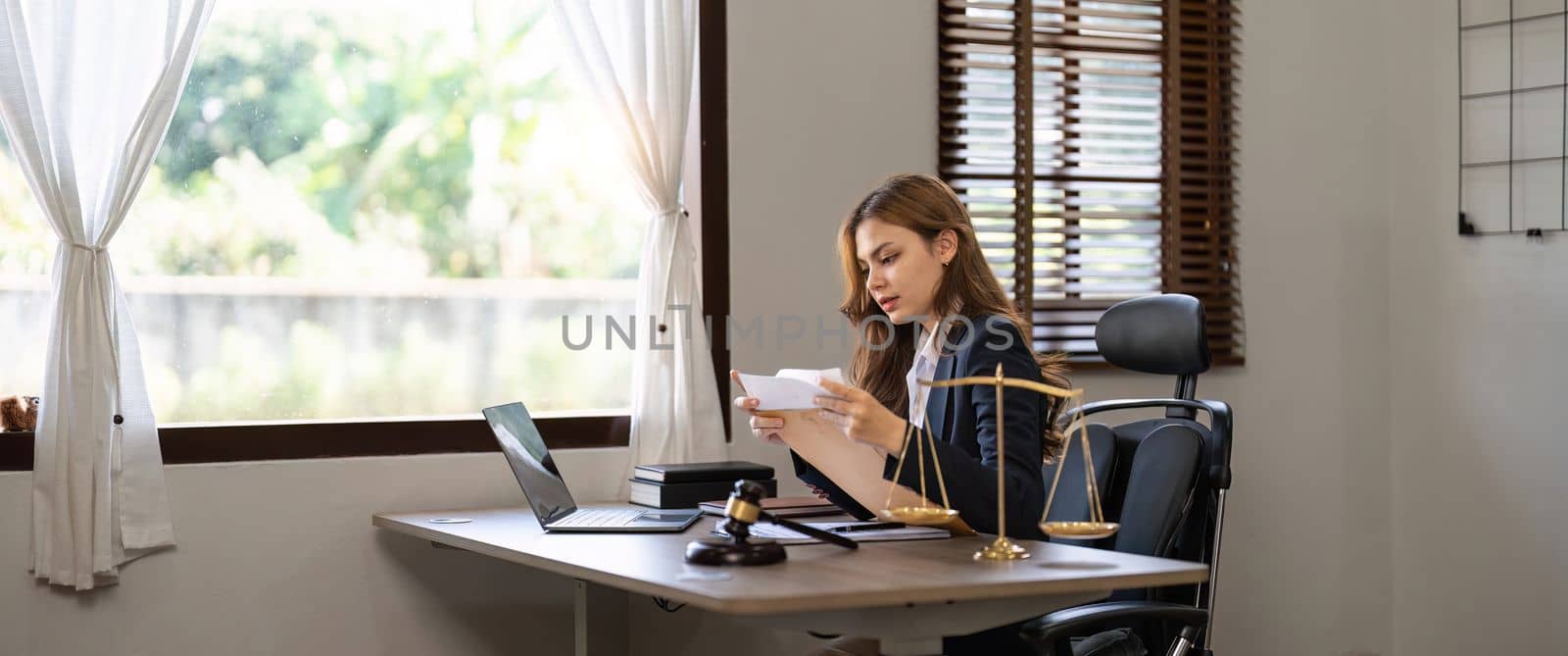 Business woman and lawyers discussing contract papers with brass scale on wooden desk in office. Law, legal services, advice, Justice and real estate concept. banner by nateemee