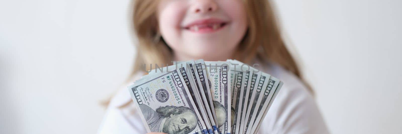 Portrait of happy girl holding cash dollars by kuprevich