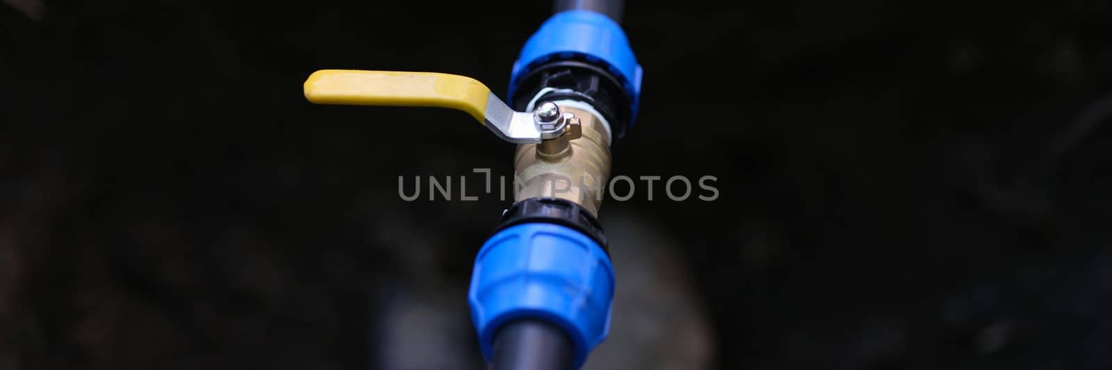 Water pipe faucet connector with closeup for watering plants in garden. Sewerage country and adapter on plastic pipe concept