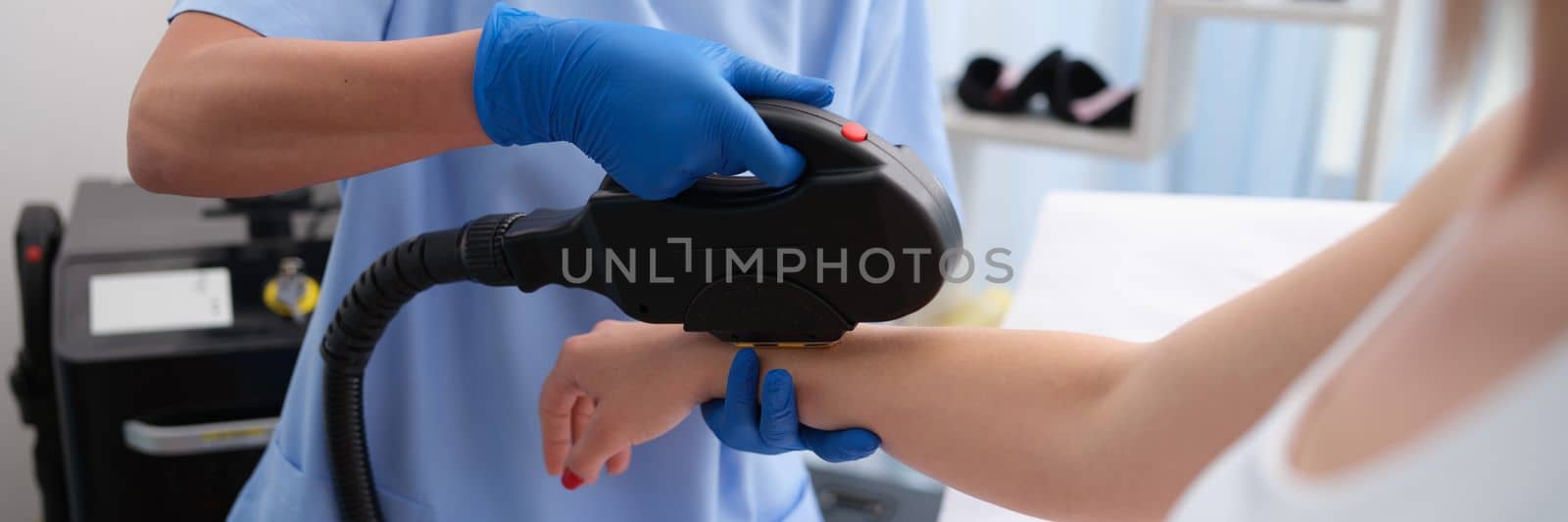 Laser hair removal on female arm in beauty parlor by kuprevich