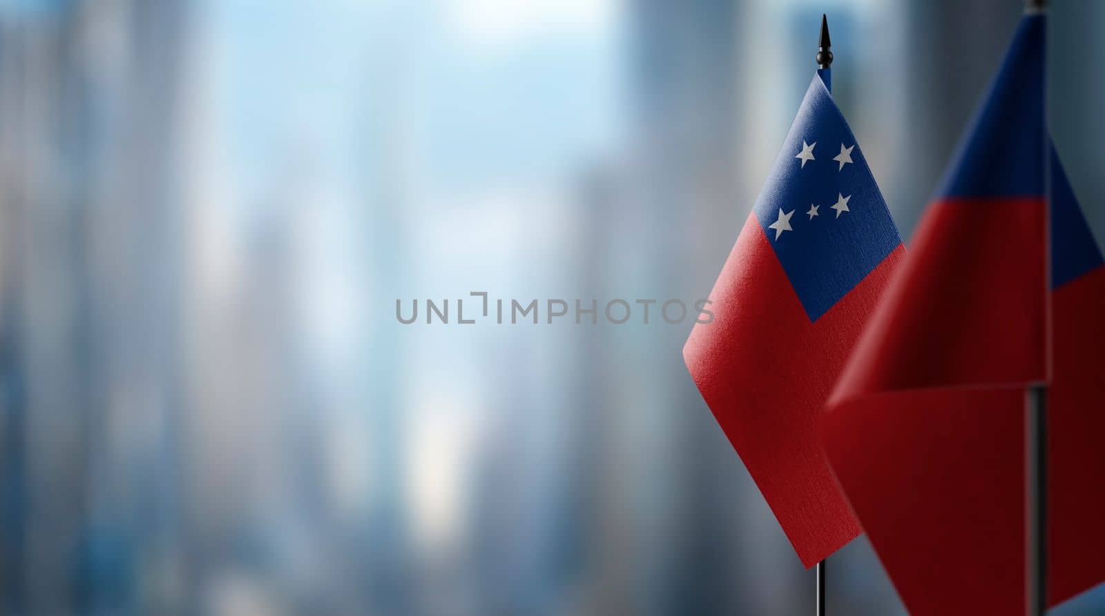 Small flags of the Samoa on an abstract blurry background.