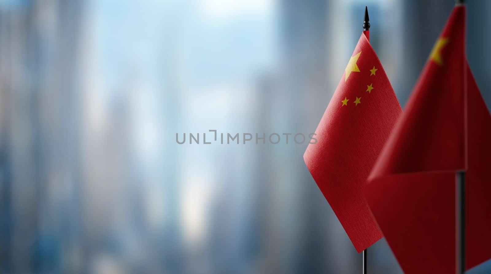 Small flags of the China on an abstract blurry background by butenkow
