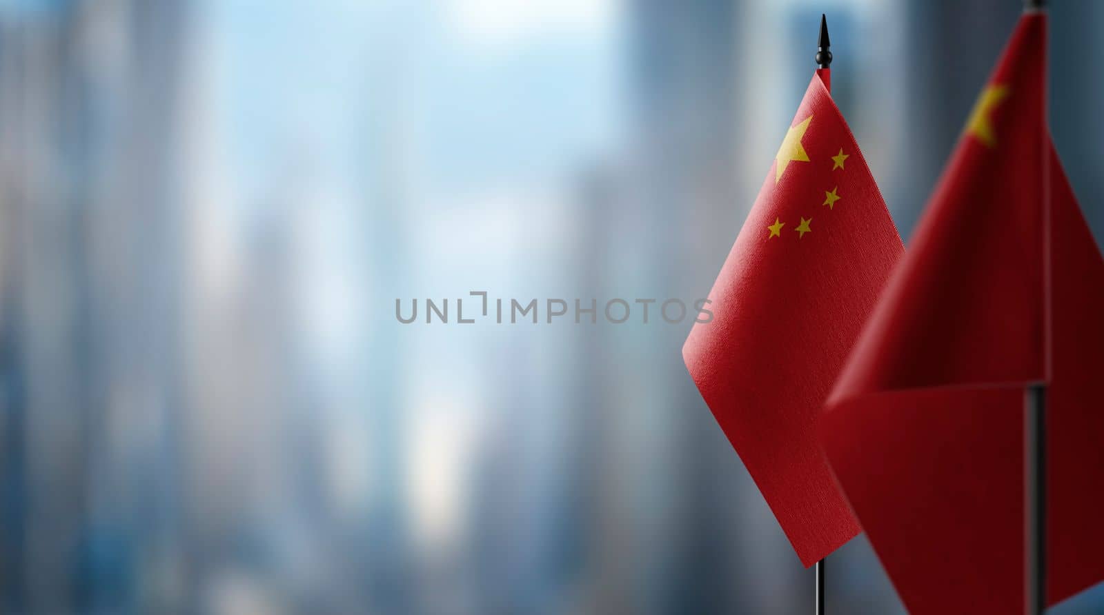 Small flags of the China on an abstract blurry background.