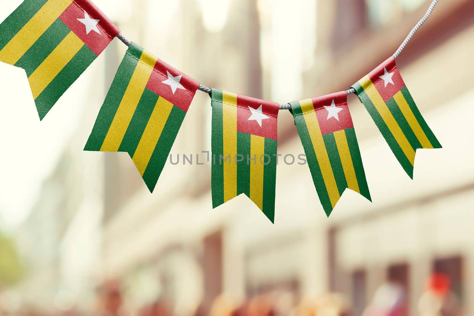 A garland of Togo national flags on an abstract blurred background.