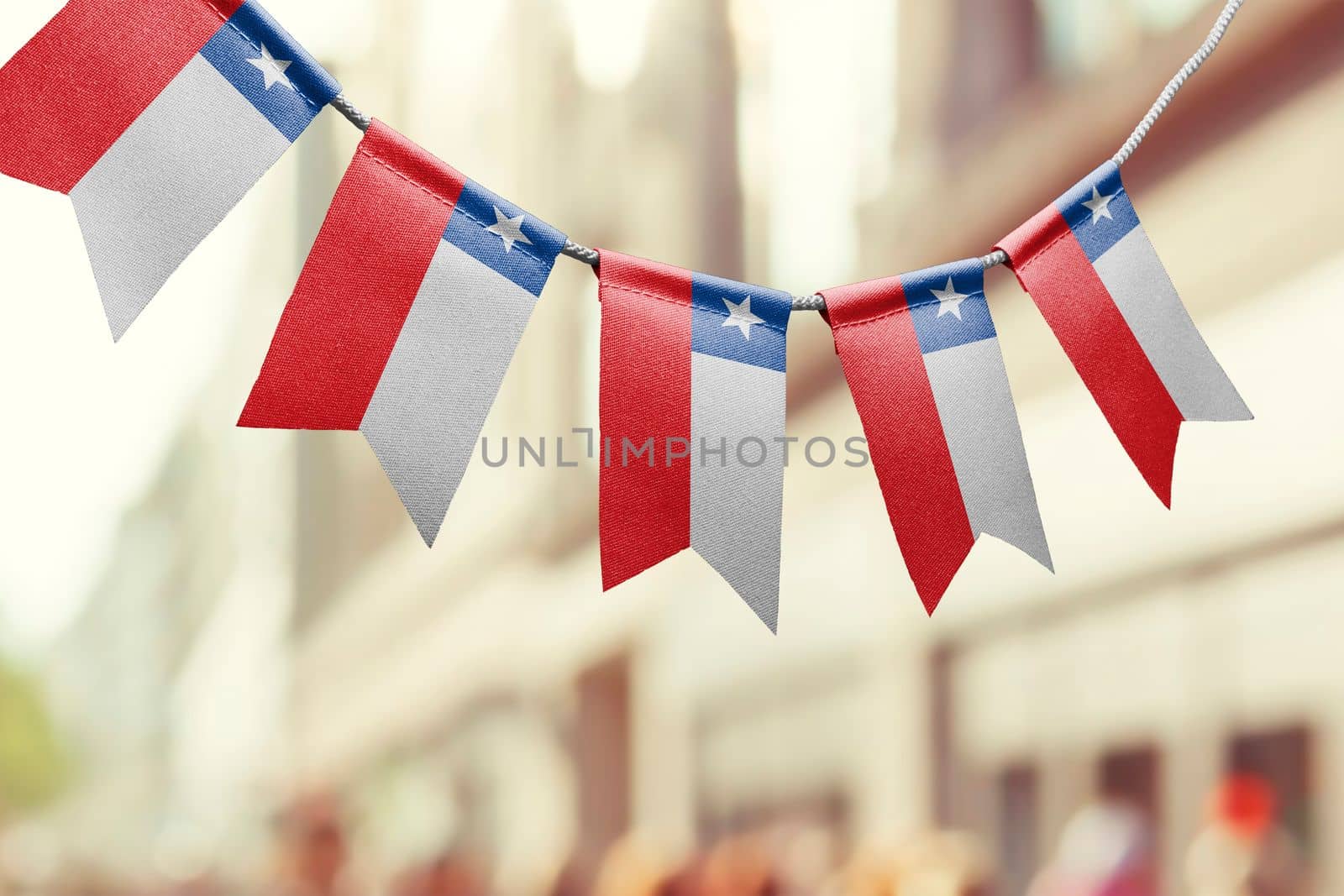 A garland of Chile national flags on an abstract blurred background.