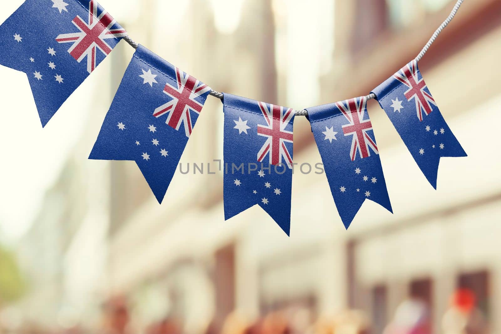 A garland of Australia national flags on an abstract blurred background.