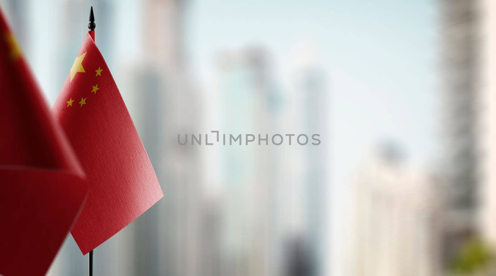 Small flags of the China on an abstract blurry background.