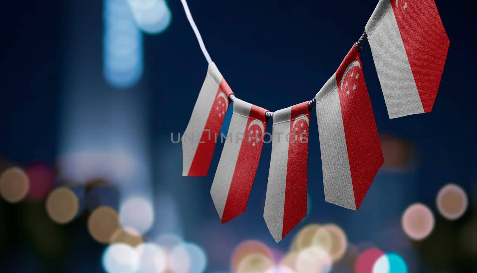 A garland of Singapore national flags on an abstract blurred background.