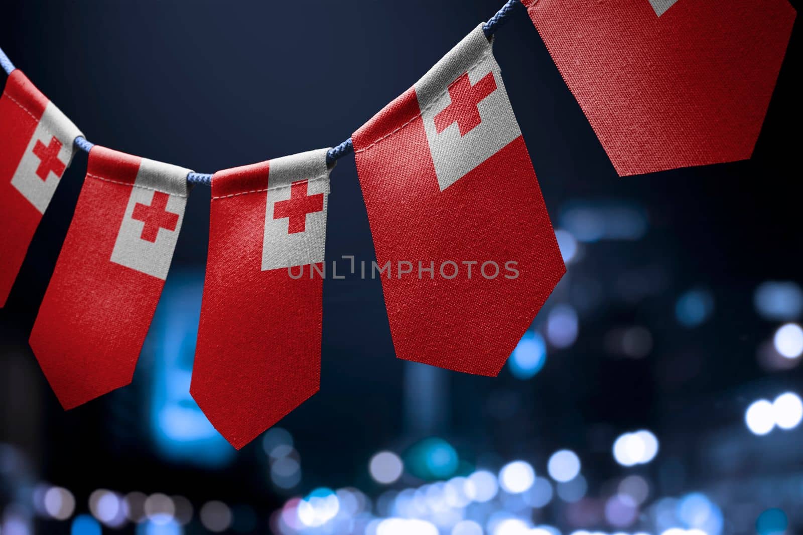 A garland of Tonga national flags on an abstract blurred background.