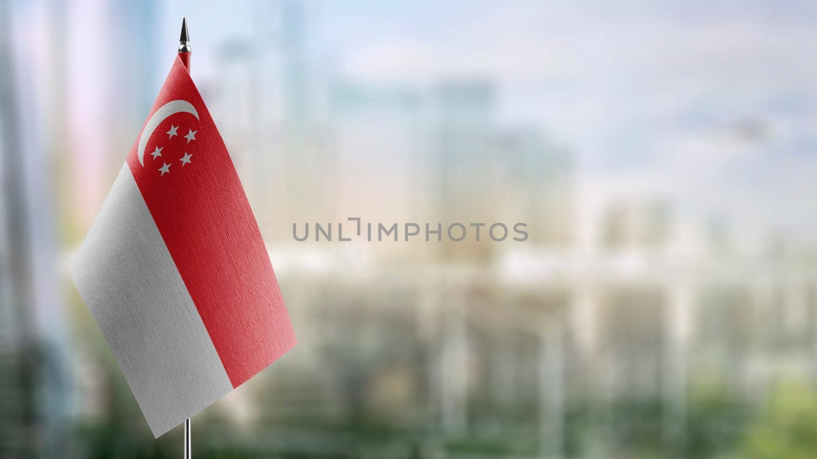 Small flags of the Singapore on an abstract blurry background.