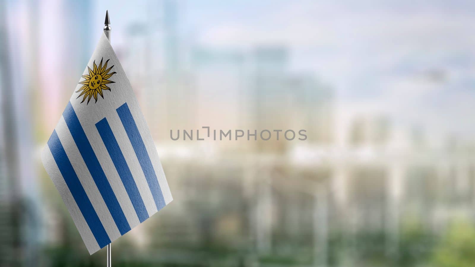 Small flags of the Uruguay on an abstract blurry background.
