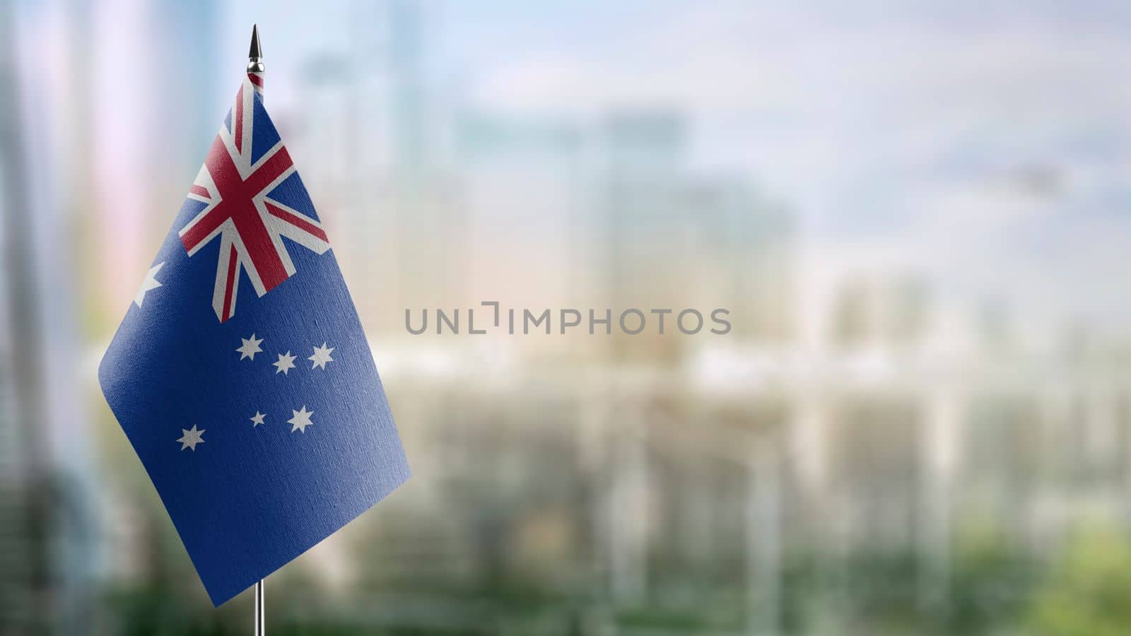 Small flags of the Australia on an abstract blurry background.