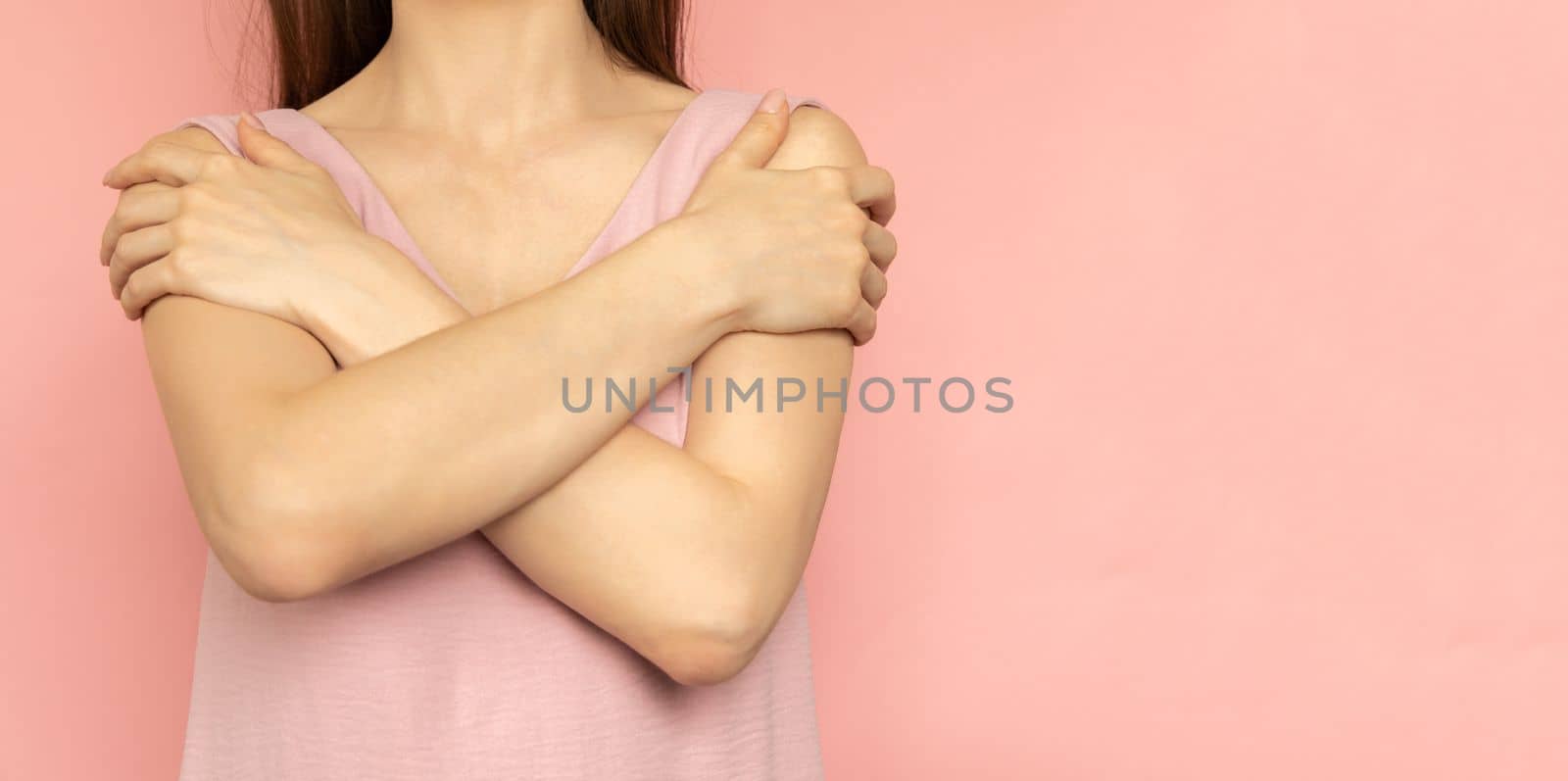 Embrace equity. Woman hug yourself dressed pastel pink dress on pink background. International women's day concept. Pastel colors, copy space