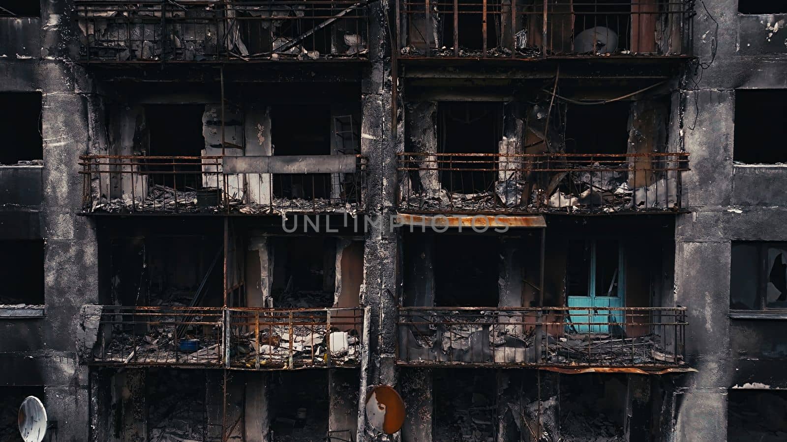 A burnt-out high-rise in the war zone. Damage to a residential building as a result of artillery shelling. War in residential areas, broken windows and burned apartments. Armed conflict in Ukraine.