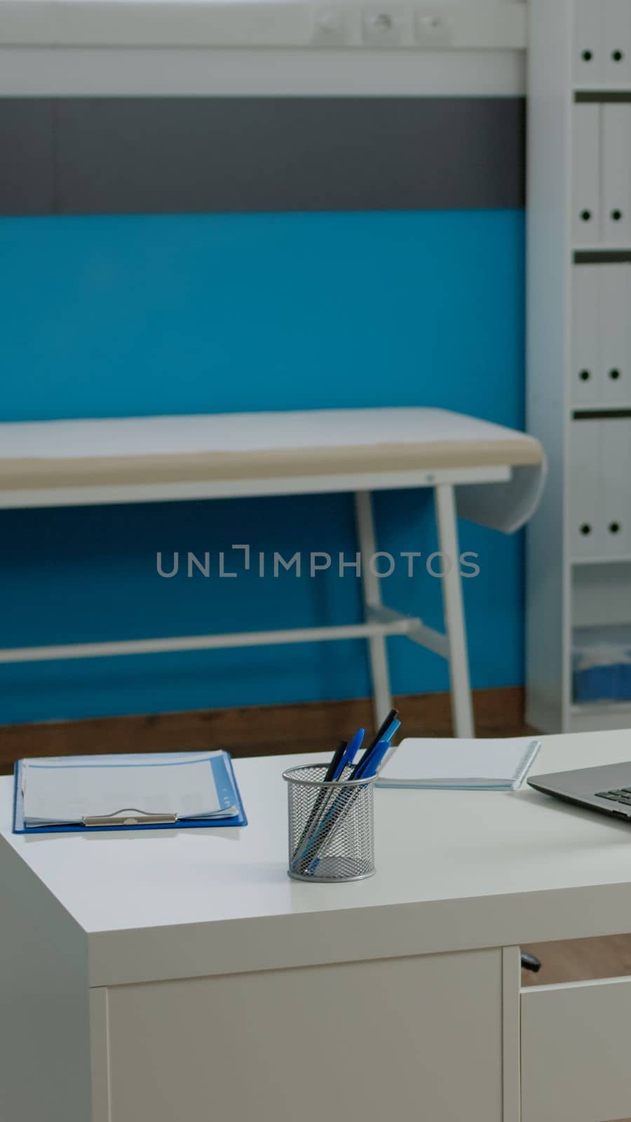 Close up of white desk in empty doctors office at healthcare clinic by DCStudio