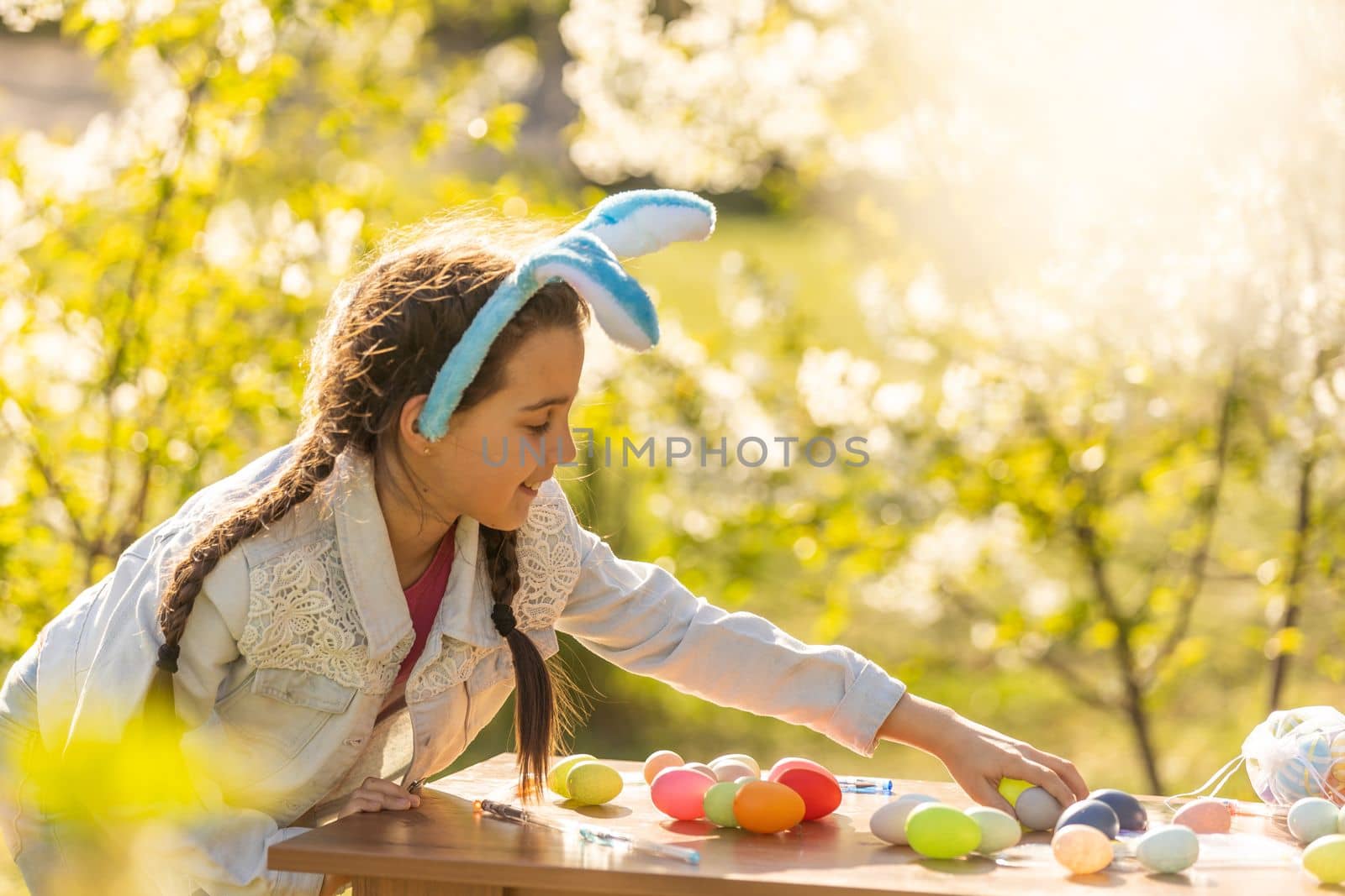 Teenage girl holding easter eggs in the backyard by Andelov13