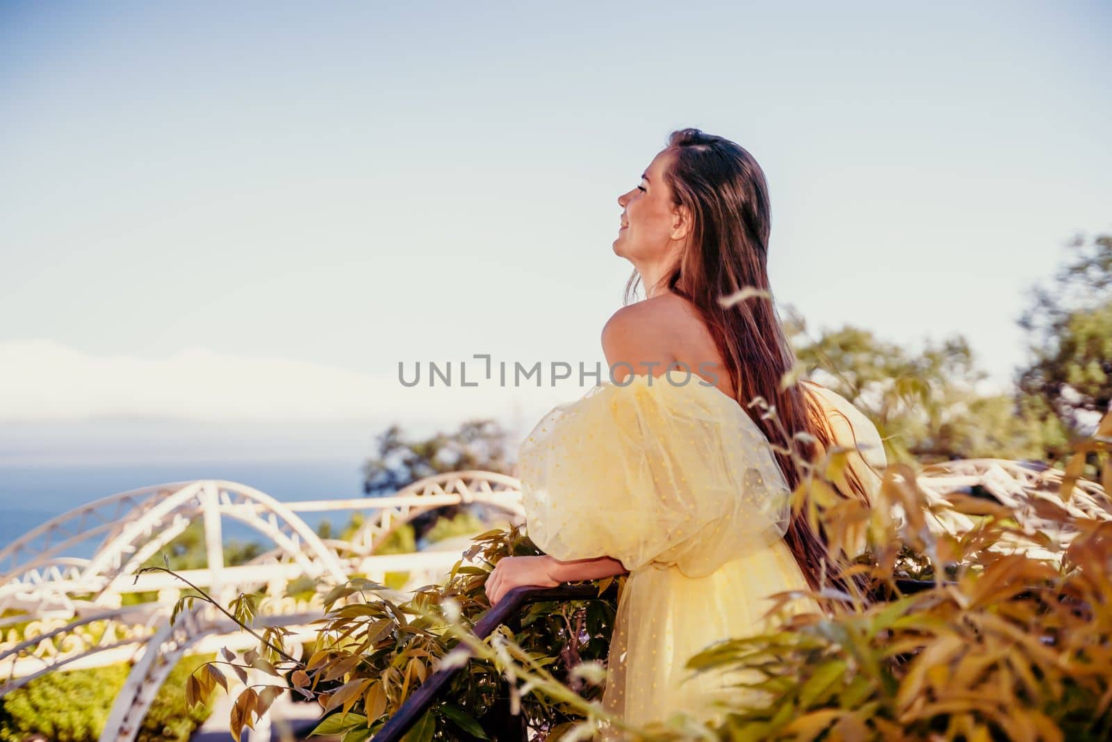 Woman yellow sea dress. Portrait of a beautiful young woman with brown hair in a gorgeous yellow dress looks into the distance. by Matiunina