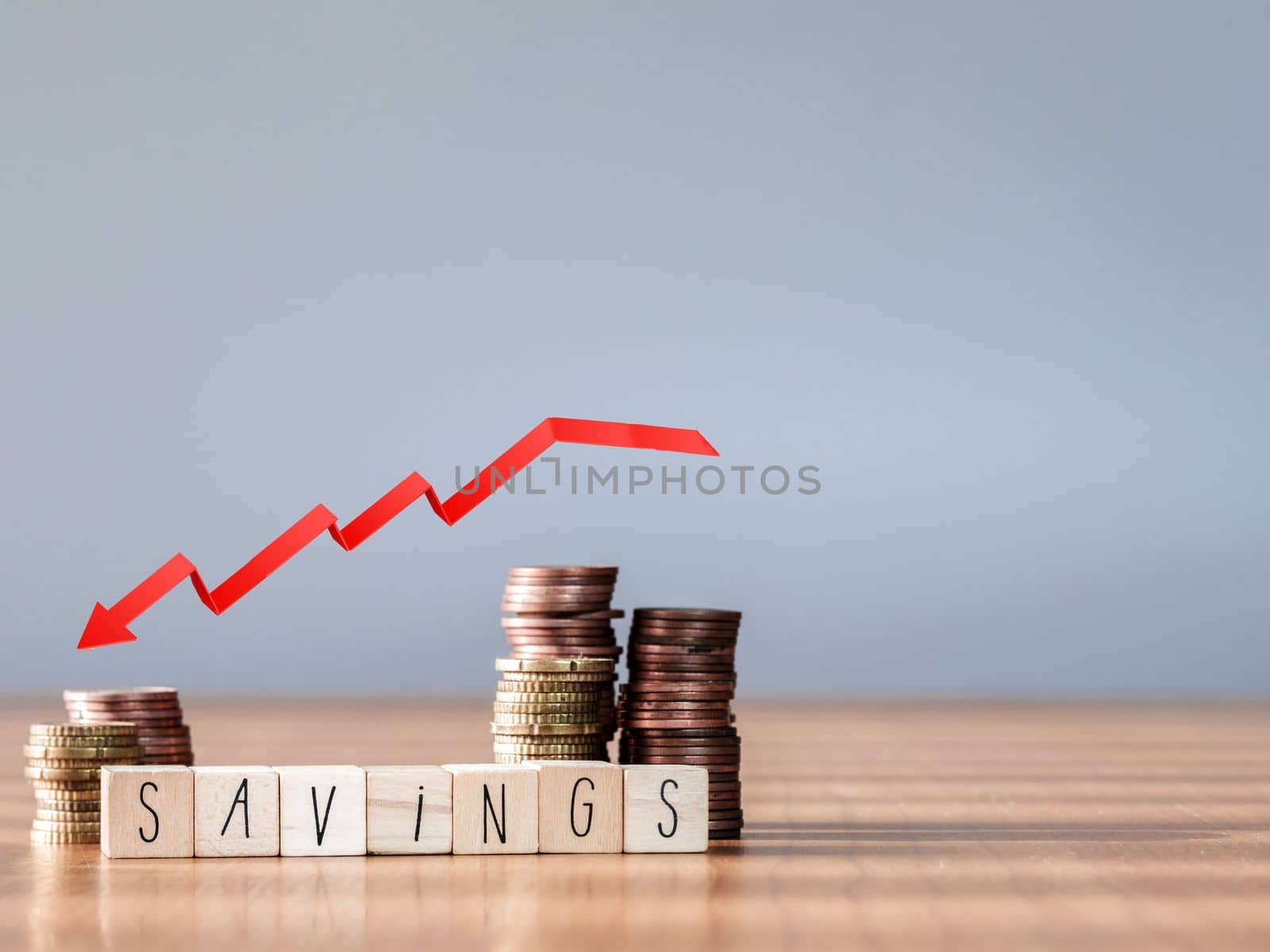 red arrow down graphic. Falling savings or bankruptcy and loss of investment.on gray background. Copy space for text savings in piggy bank and coin stairs poor