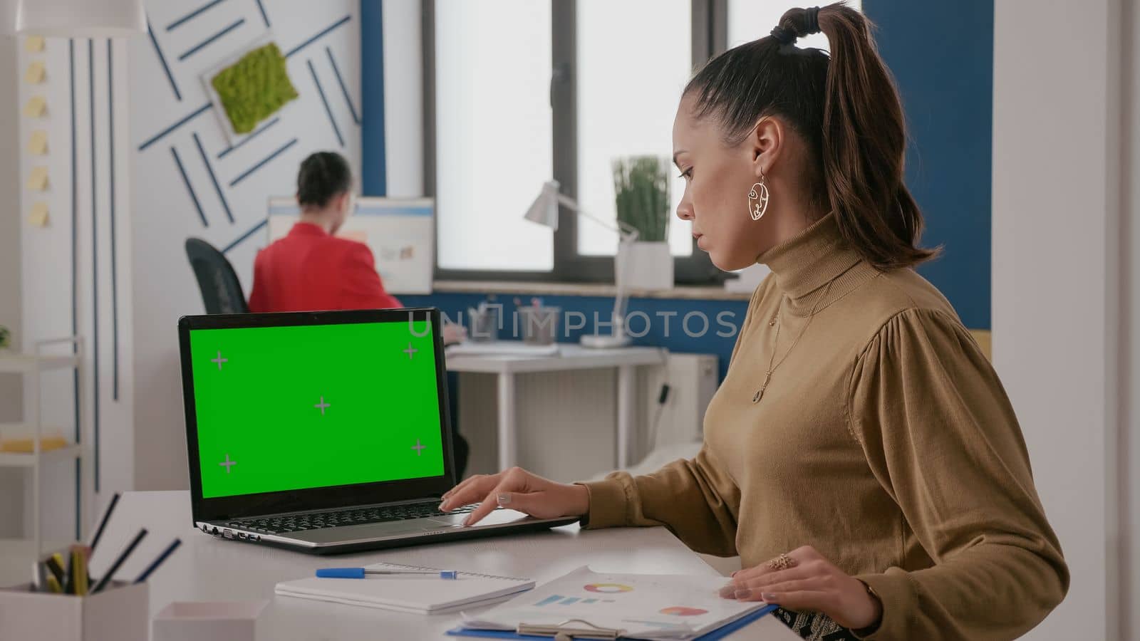 Business woman working with green screen on laptop, computer with mock up background and isolated copy space template on chroma key. Worker using chroma-key mockup on screen display.