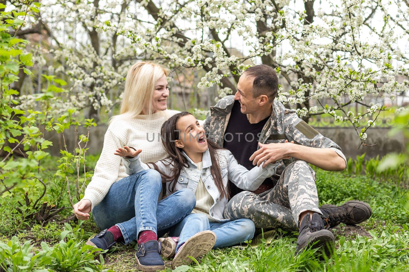 Handsome soldier reunited with family on a sunny day. by Andelov13