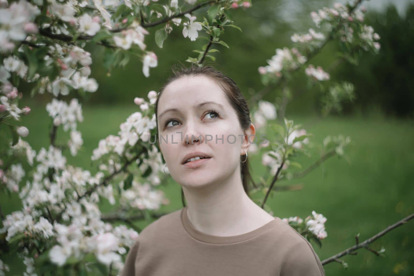 Beautiful young woman near blooming spring tree. Youth, love, fashion, romantic and lifestyle concept by paralisart