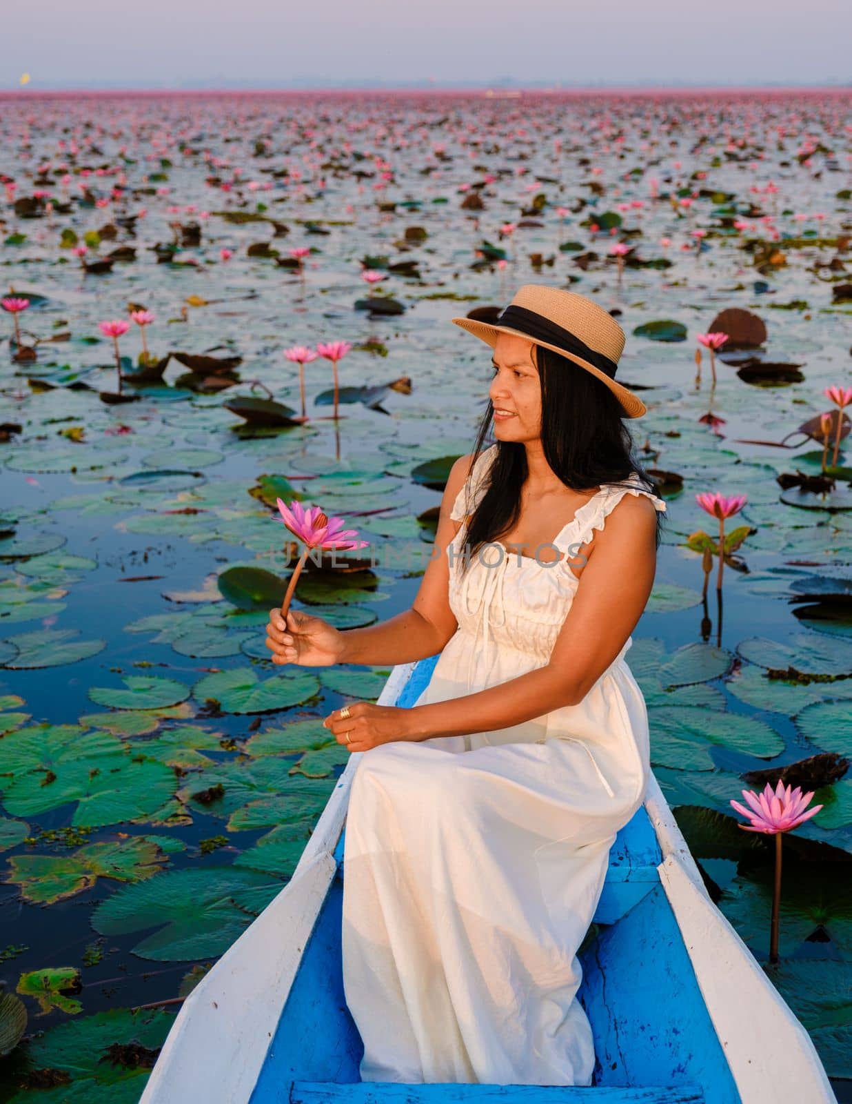 Asian women in a boat at the Beautiful Red Lotus Sea in Udon Thani in northern Thailand. Flora of Southeast Asia.