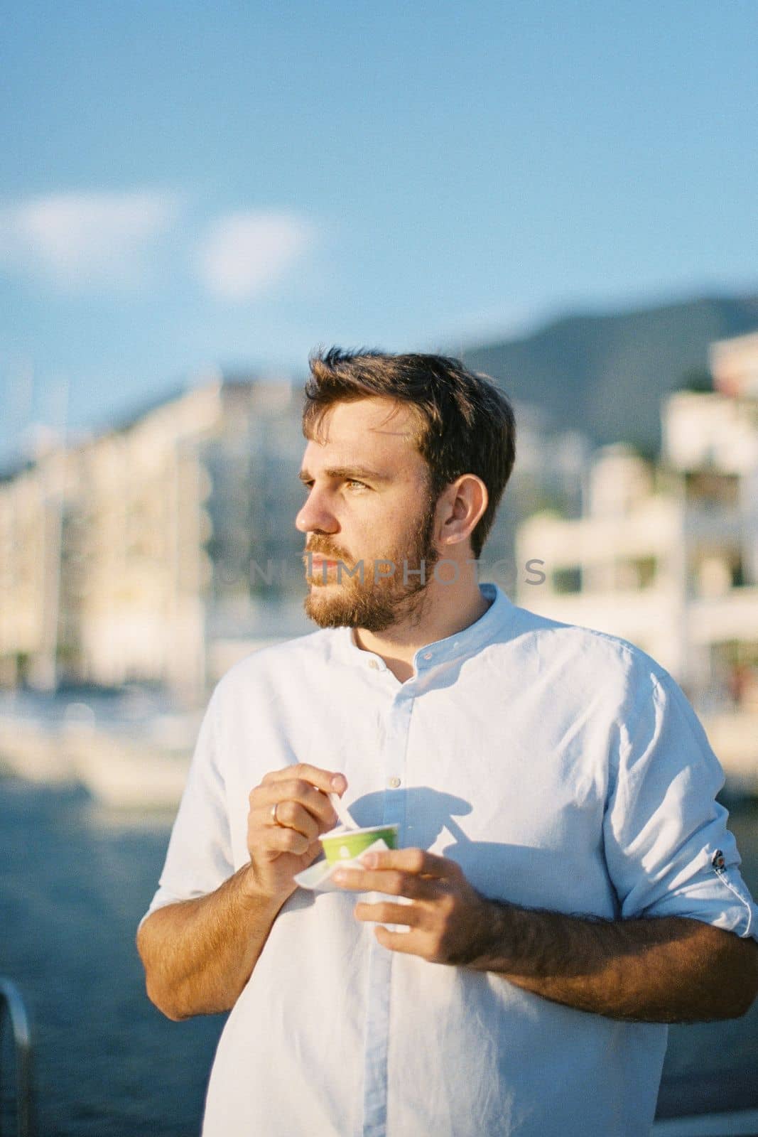 Young man with ice cream in his hands turned his head to the side. High quality photo