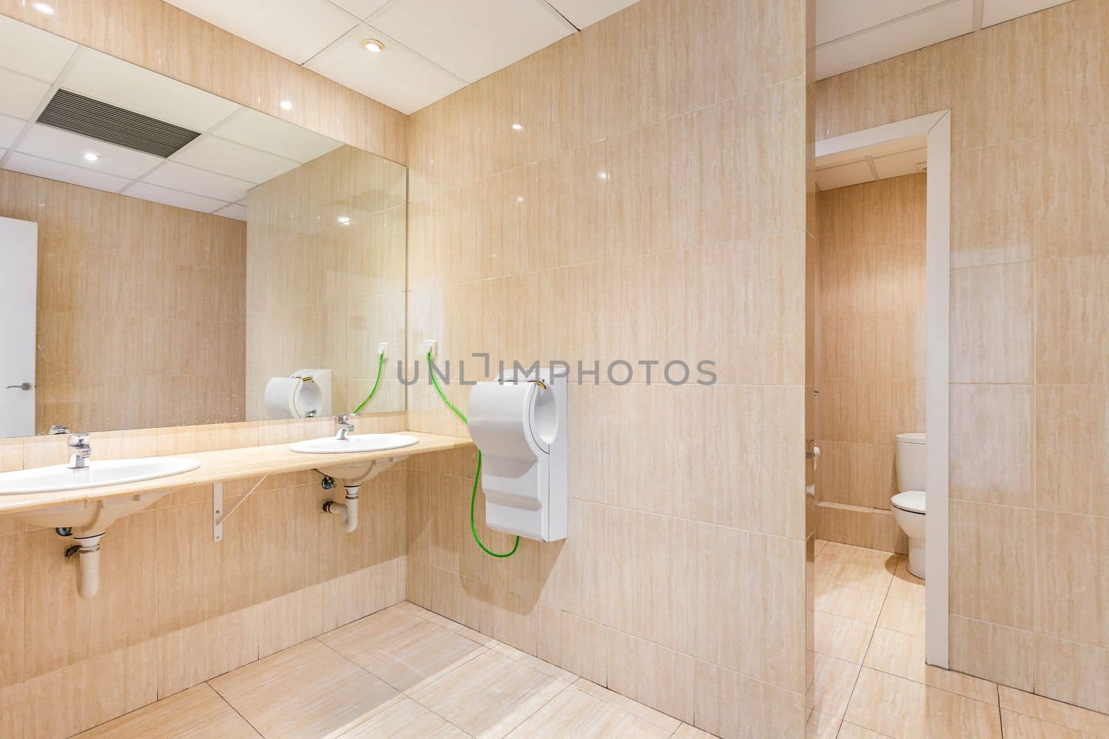 Public toilet with big mirror, handwashers, dryer and wc doors