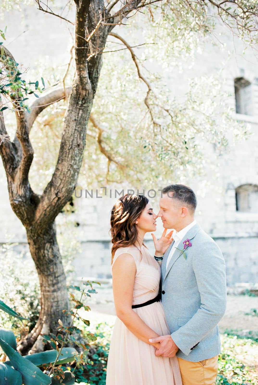 Bride and groom almost kiss near the old fortress. High quality photo
