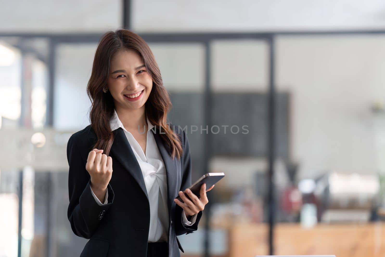 Young happy lucky Business woman feeling excited winner looking at cellphone using mobile phone winning online, receiving great news or sms offer.