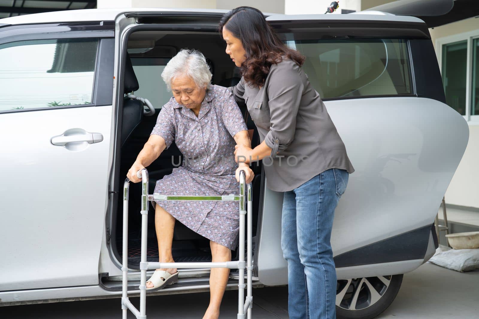 Asian senior woman patient sitting on walker prepare get to her car, healthy strong medical concept. by pamai