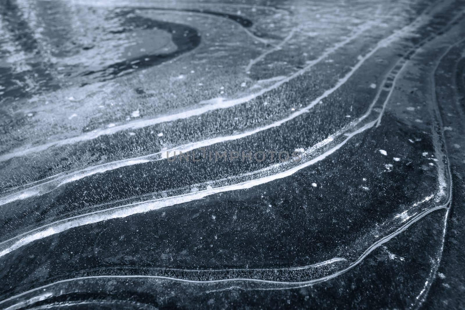 Abstract winter photo with beauty of a dark, icy landscape, with snowflakes forming delicate curves against a contrasting white backdrop. The minimalist composition and monochromatic palette create a moody, mysterious atmosphere, making it perfect for backgrounds, graphic designs, and illustrations by LipikStockMedia