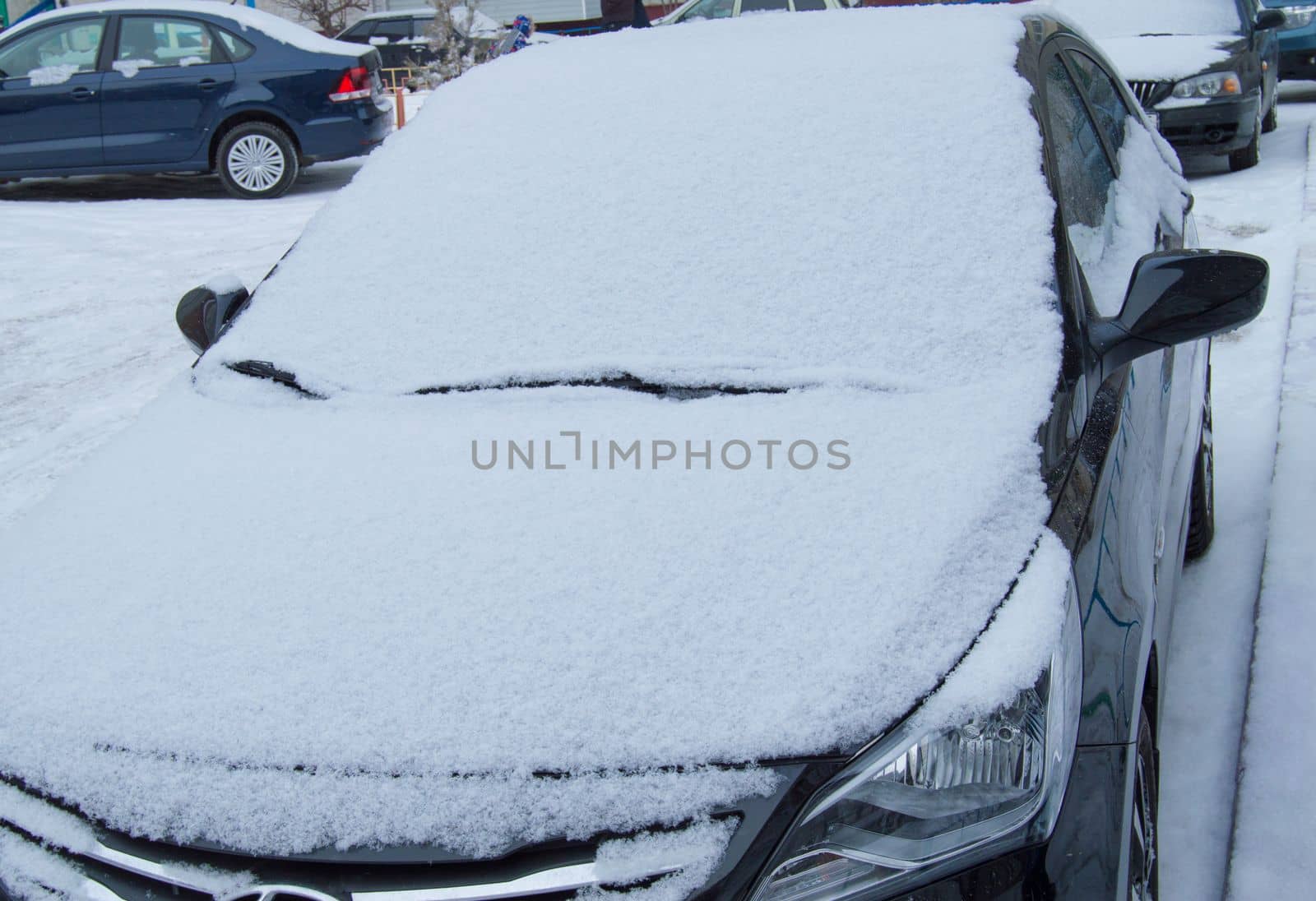 parked car is on the road, covered with snow