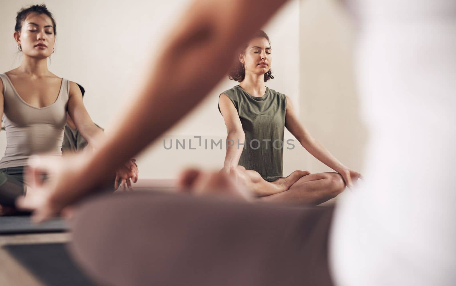 Treat your body with some meditating and yoga. a group of young people meditating and practicing yoga together inside a yoga studio. by YuriArcurs