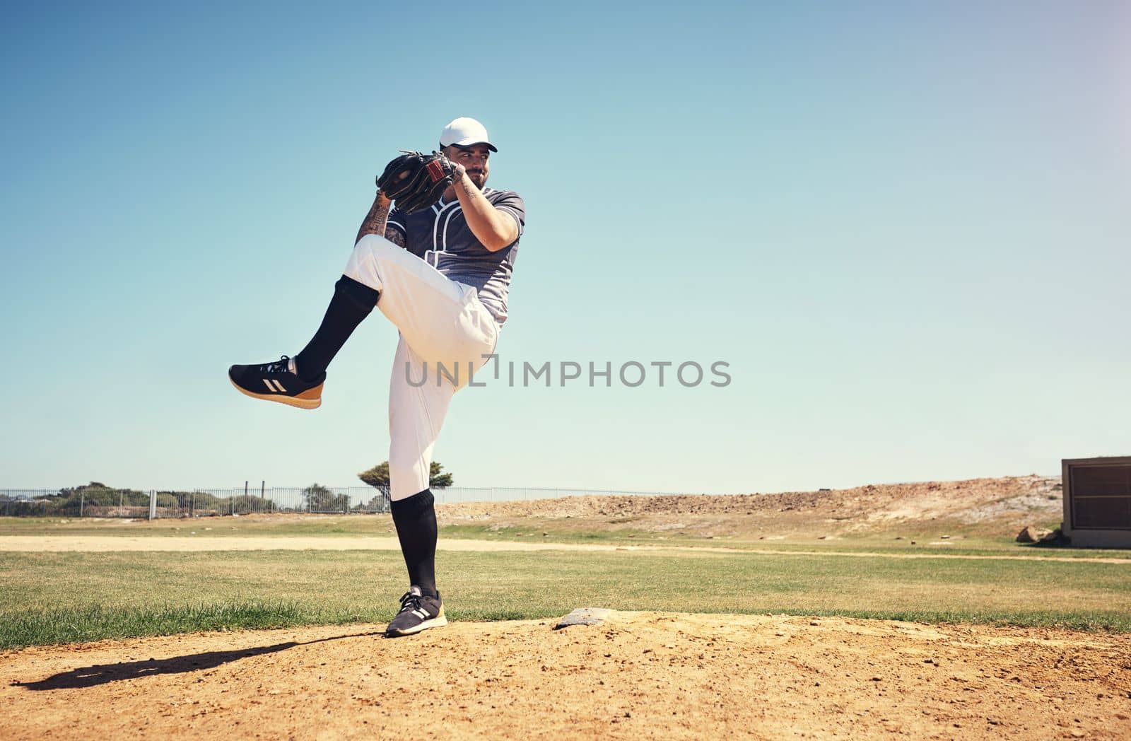 You cant coach this kind of skill. a young man pitching a ball during a baseball match