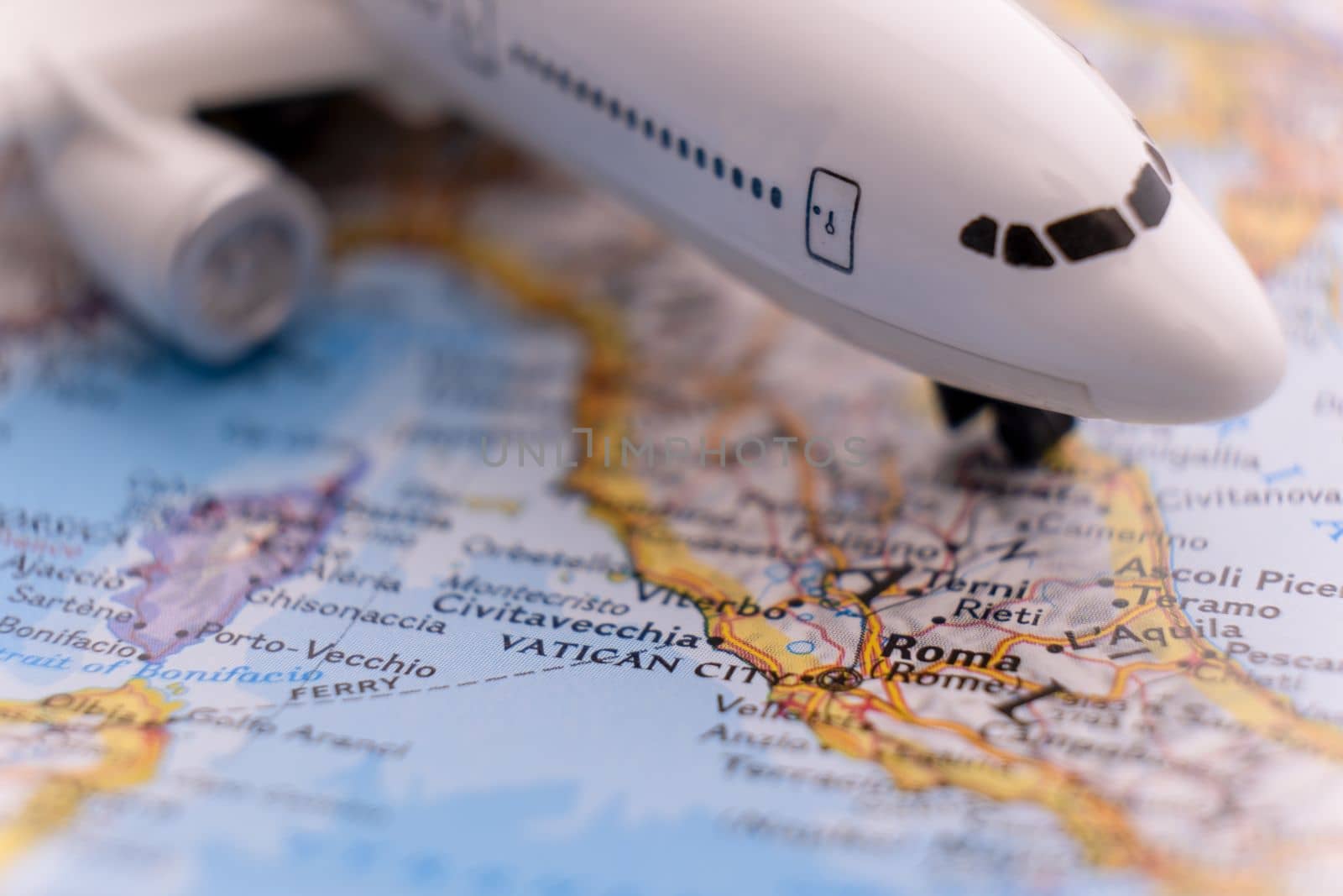 Passenger plane on a map highlighting Rome, Italy through selective focus, background blur. High quality photo