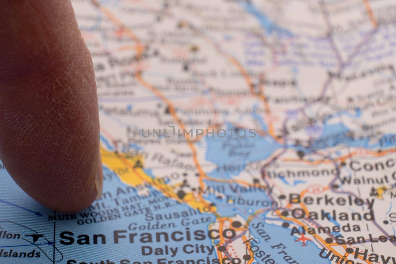 Finger pointing to San Francisco, California on colorful map with selective focus, shallow depth of field, background blur. High quality photo