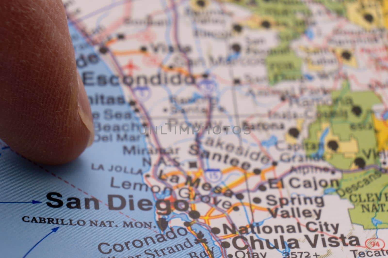 Finger pointing to San Diego, California on colorful map with selective focus, shallow depth of field, background blur. High quality photo