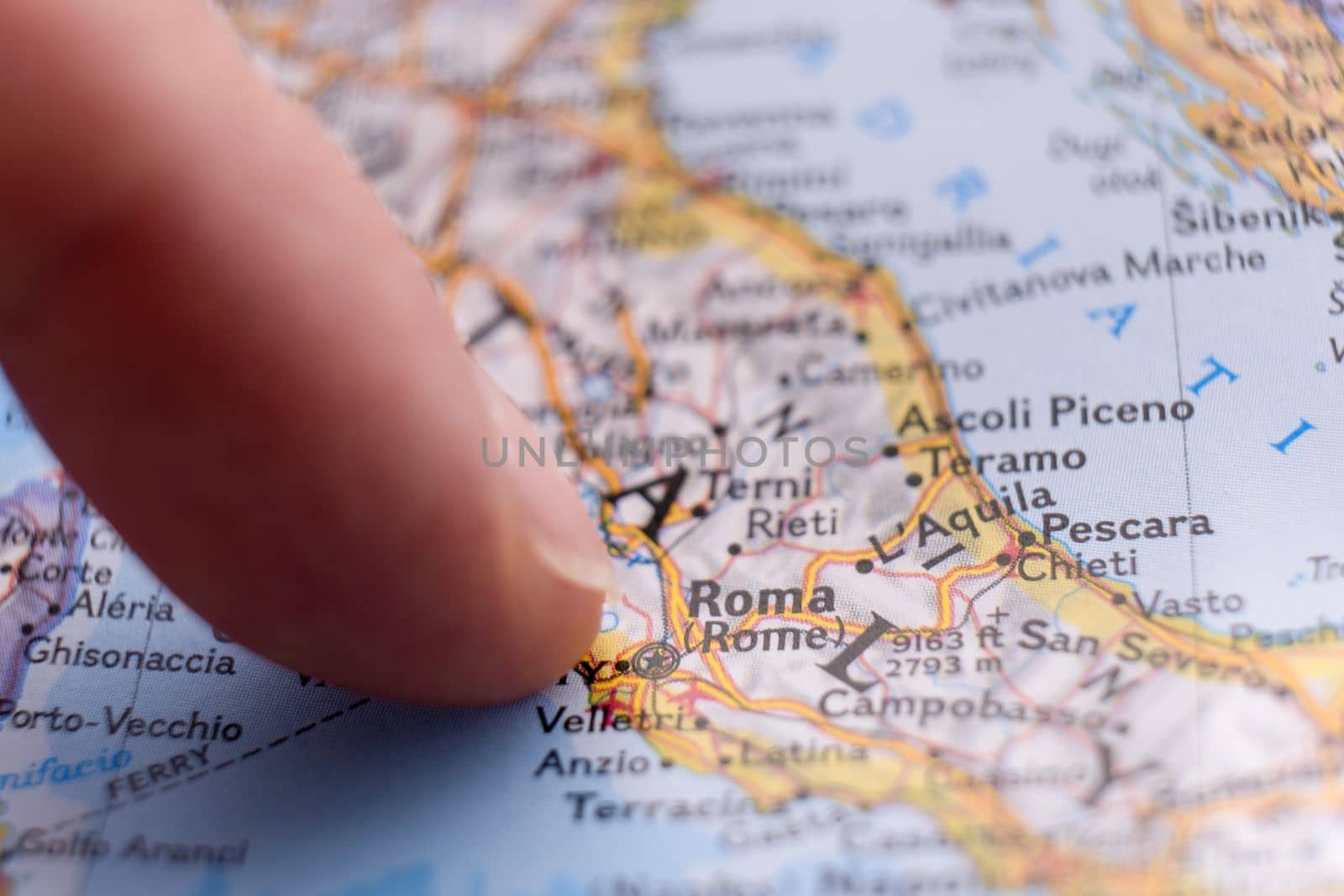 Finger pointing to Rome, Italy on colorful map with selective focus, shallow depth of field, background blur. High quality photo