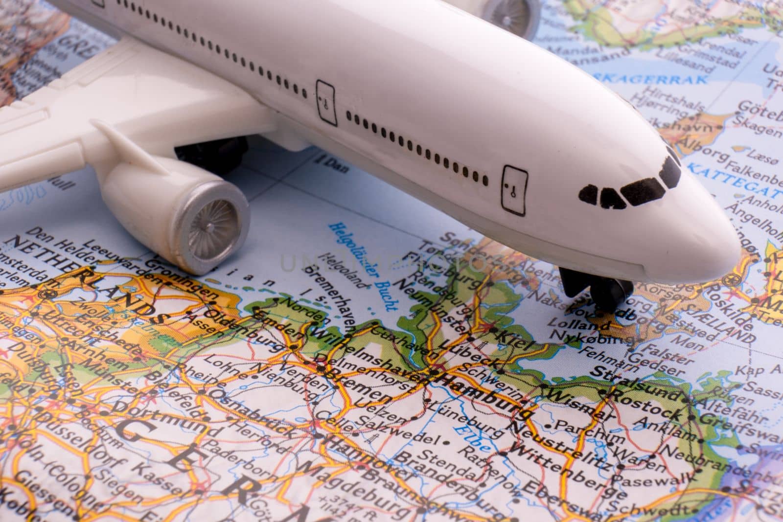 Close up of map with miniature passenger plane highlighting Hamburg, Germany through selective focus, shallow depth of field, background blur. High quality photo