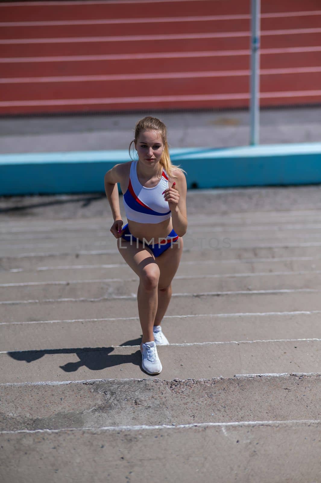 Young caucasian woman running on stadium stairs outdoors