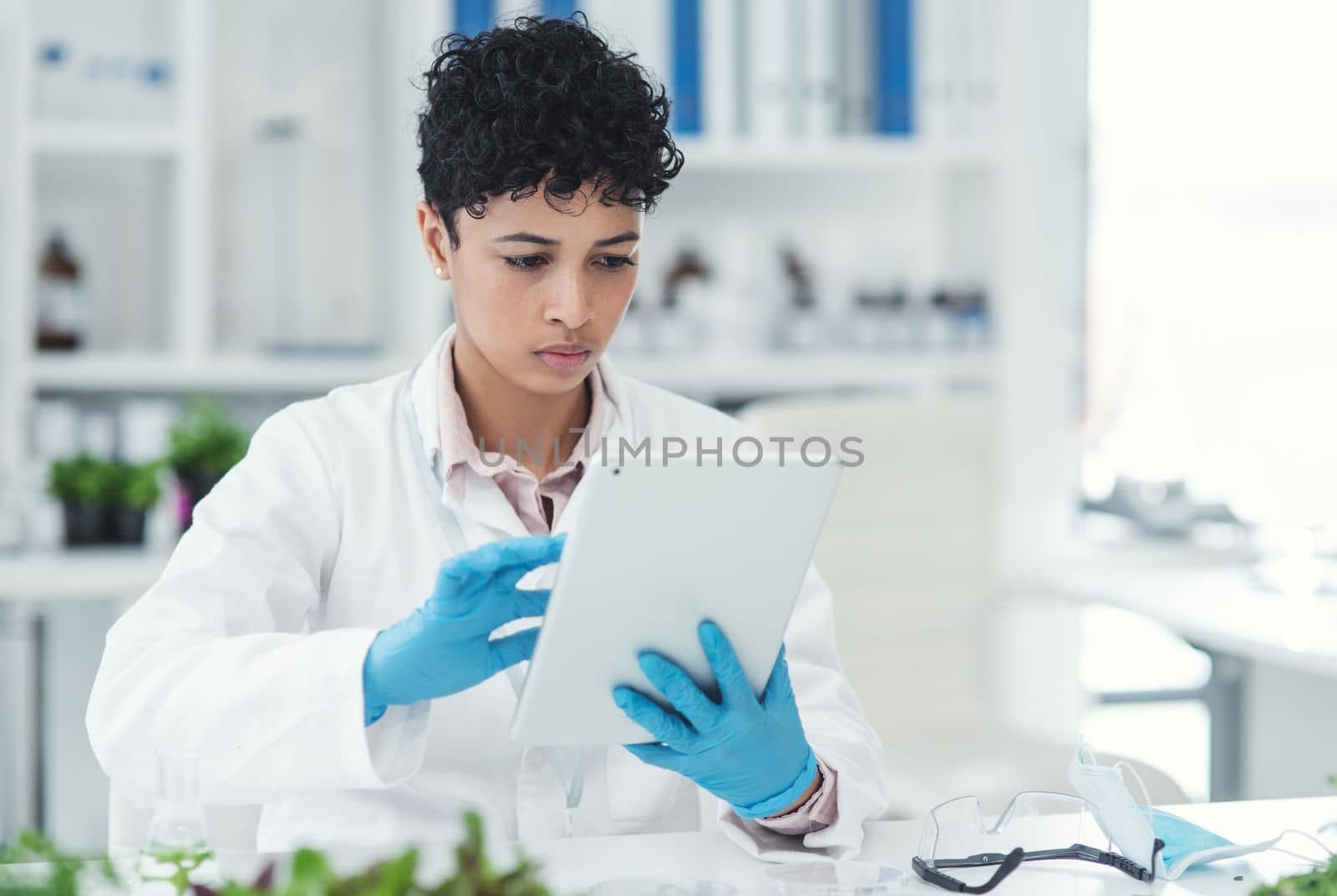 All the online resources she needs at the swipe of her fingers. an attractive young female scientist using a digital tablet while working in a laboratory. by YuriArcurs