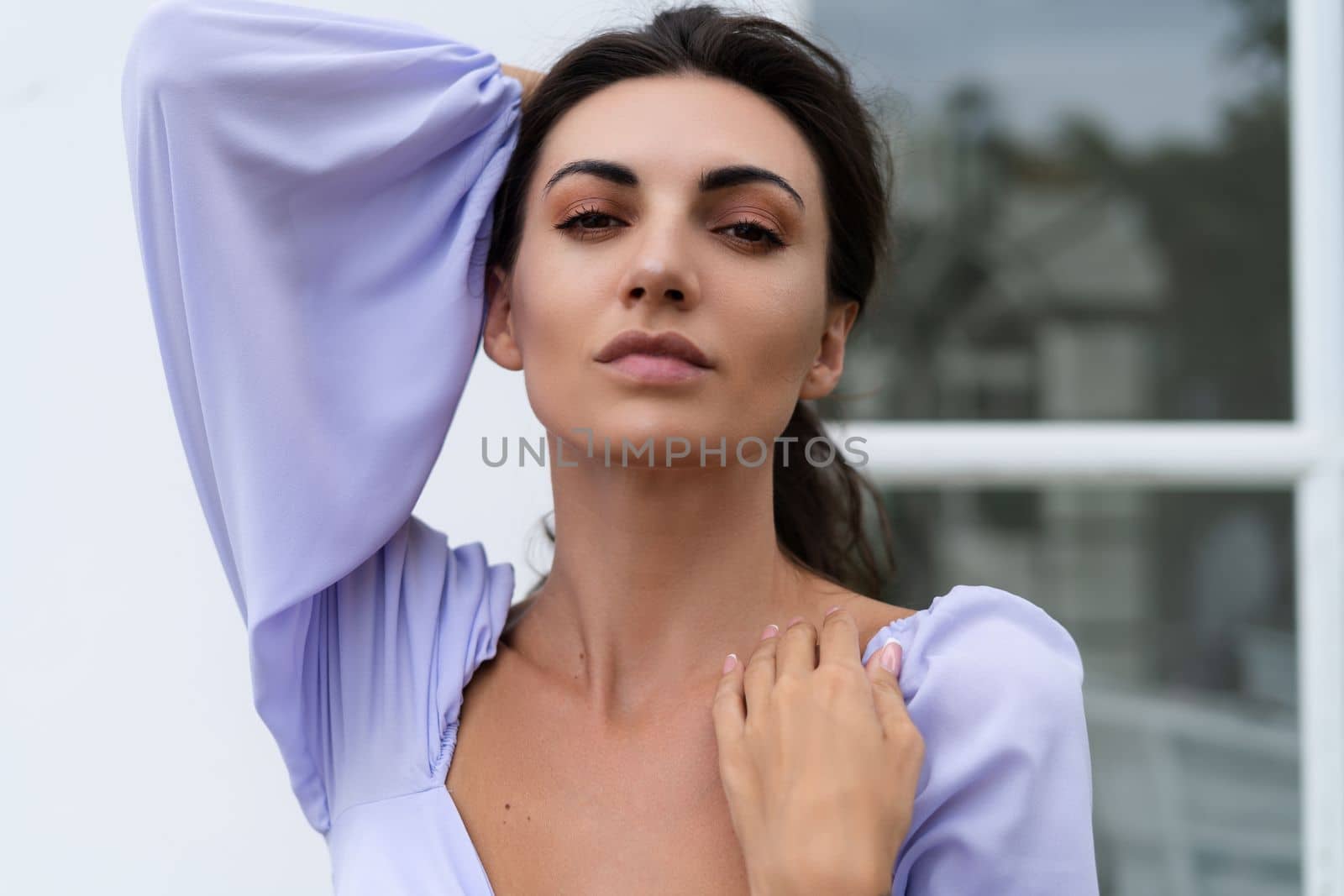 Pretty young stylish woman in trendy purple crop top long sleeve, isolated, white wall, natural day light.. by kroshka_nastya