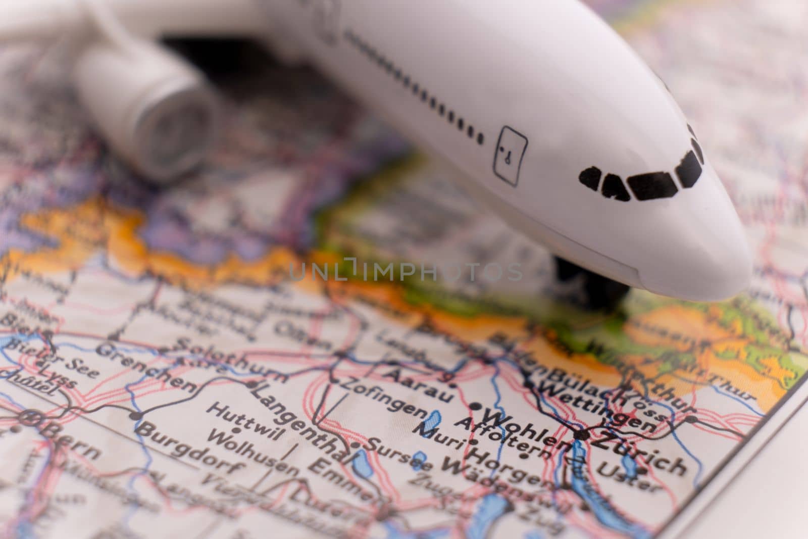Close up of a miniature passenger plane on a colorful map showing Zurich, Switzerland through selective focus, background blur. High quality photo