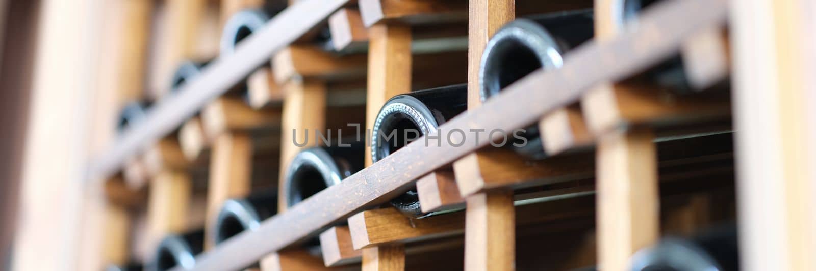 Many wine bottles in wine cellar closeup. Premium alcohol in store concept
