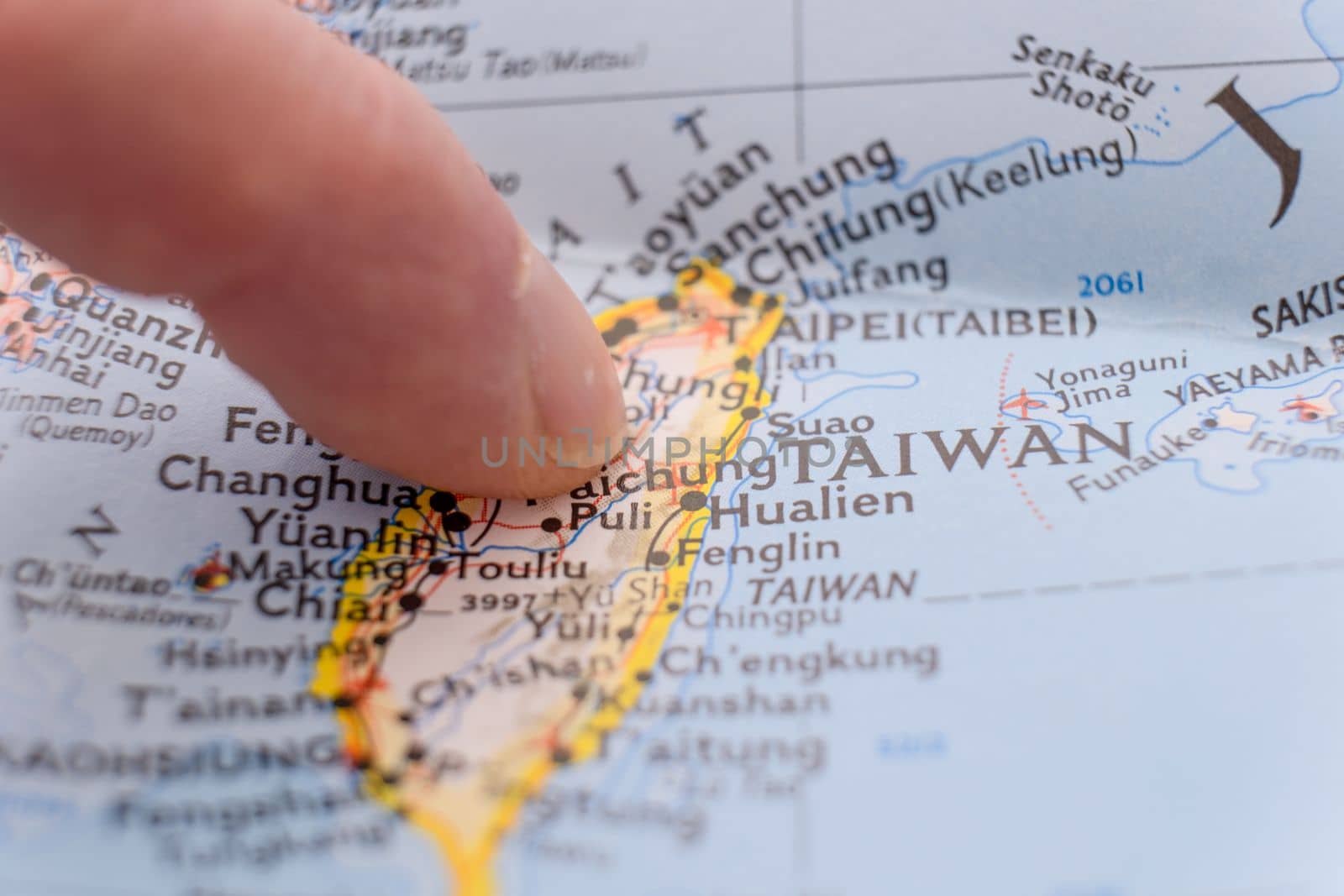 Finger pointing to Taiwan with shallow depth of field, background blur. Concept geopolitics. High quality photo