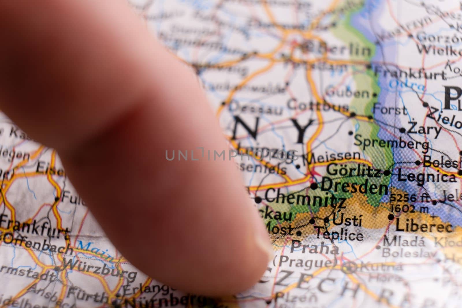 Finger pointing to Prague, Czech Republic on colorful map with selective focus, shallow depth of field, background blur. High quality photo