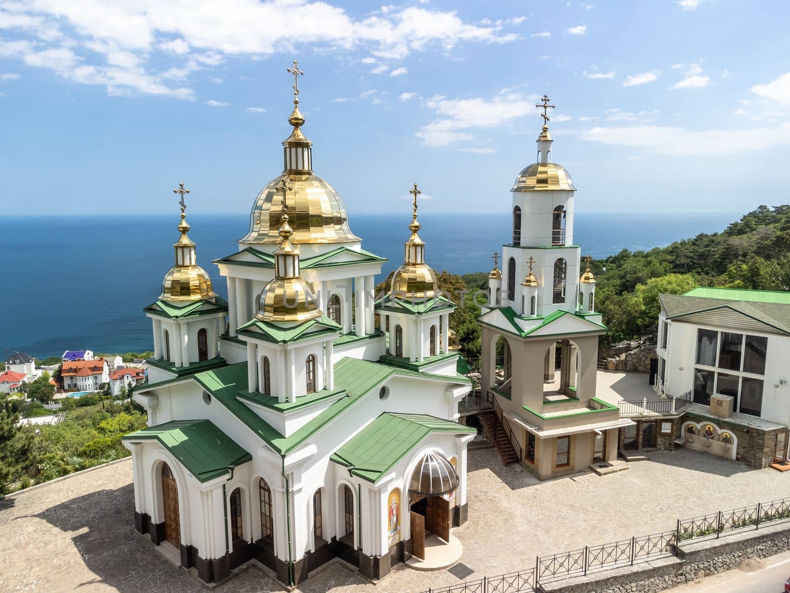 Christian church on a background of mountains. Temple of the Holy Archangel Michael in Oreanda. The southern coast of Crimea. Located on a rocky cliff and is surrounded by beautiful vegetation